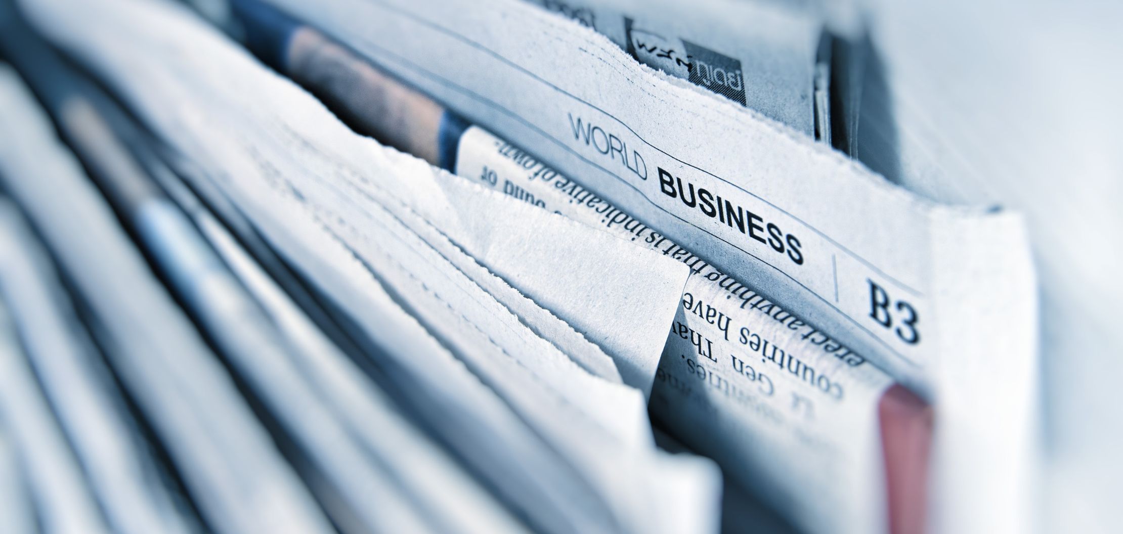 Loosely folded newspaper pages with one clearly visible header reading "World Business".
