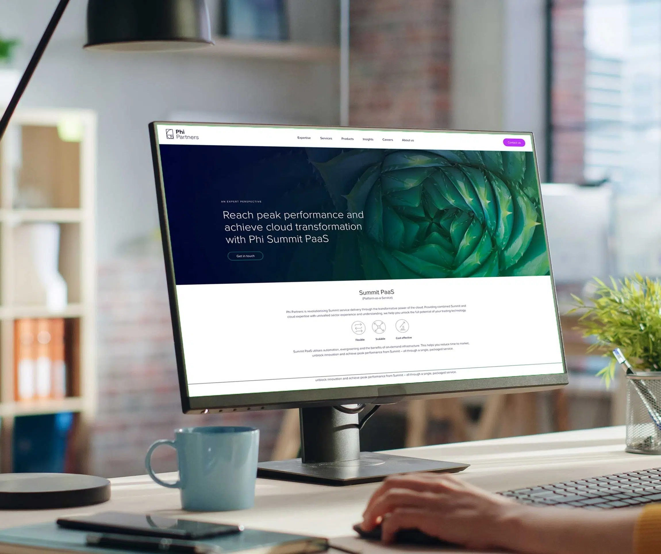 Phi Partners' Peak Performance campaign imagery showcasing the website home page for Summit PaaS on a desktop PC in a modern office.