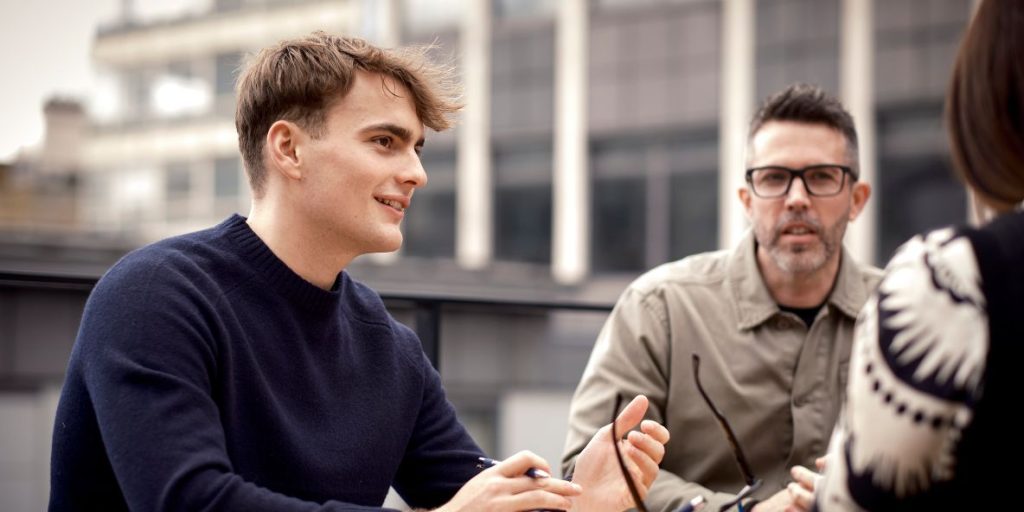 group of three people talking