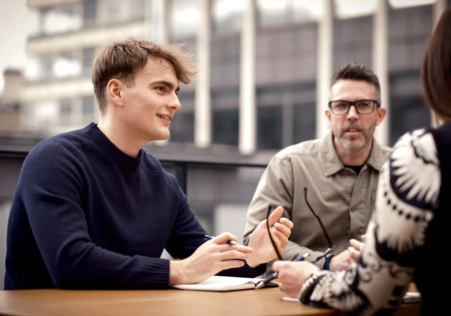 group of three people talking