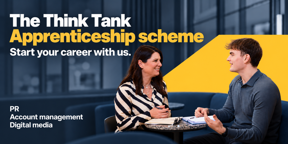 2 colleagues sitting at a table having a meeting. Apprenticeship scheme text over image.